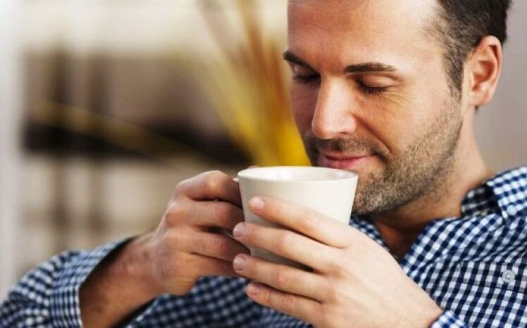 Los hombres beben una taza de té de marihuana para aumentar la potencia